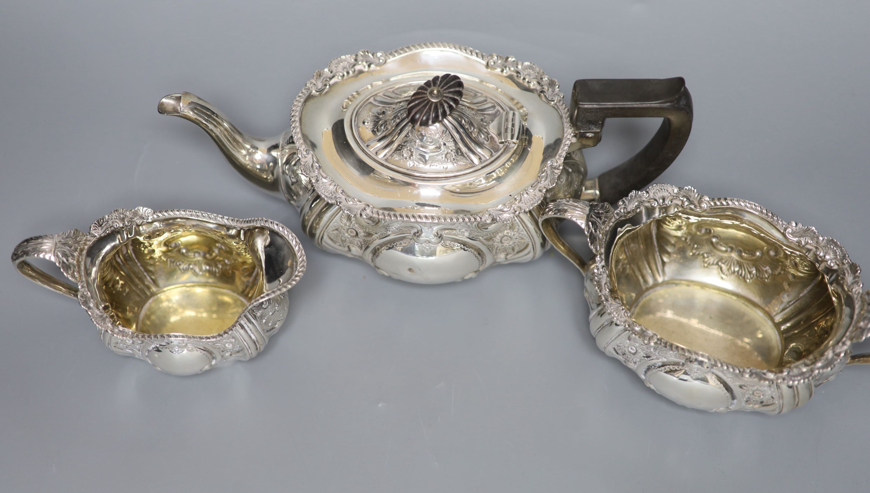 An Edwardian embossed silver three piece tea set, Hammond, Creake & Co, Sheffield, 1903